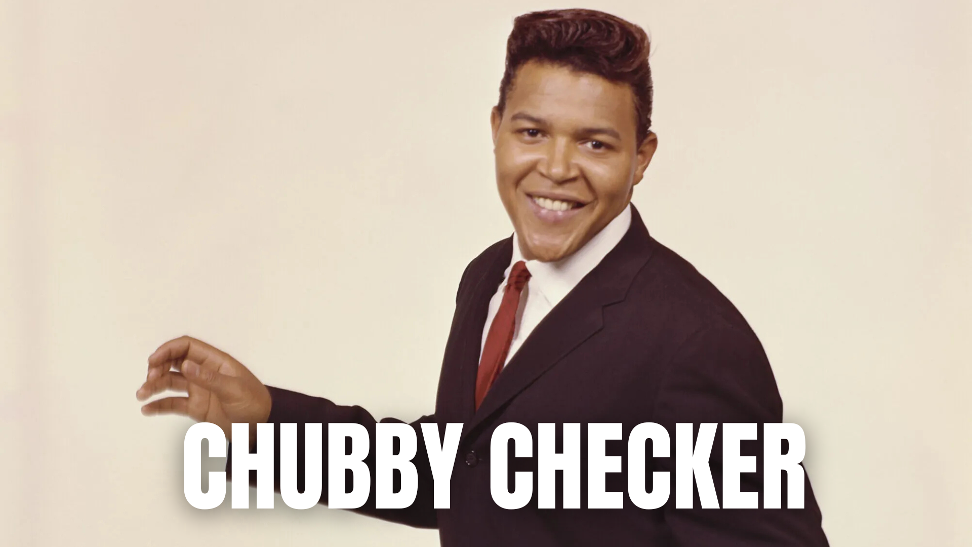 A smiling man in a suit with text 'CHUBBY CHECKER'.
