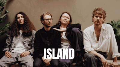 A group of people sitting closely with a 'ISLAND' text overlay.